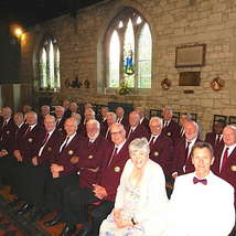 Newchurch male voice choir seated and smiling