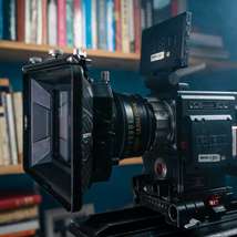 Film camera set up in front of book shelves by nata figueiredo