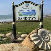 Welcome to sandown sign with bay in the background   paul coueslant